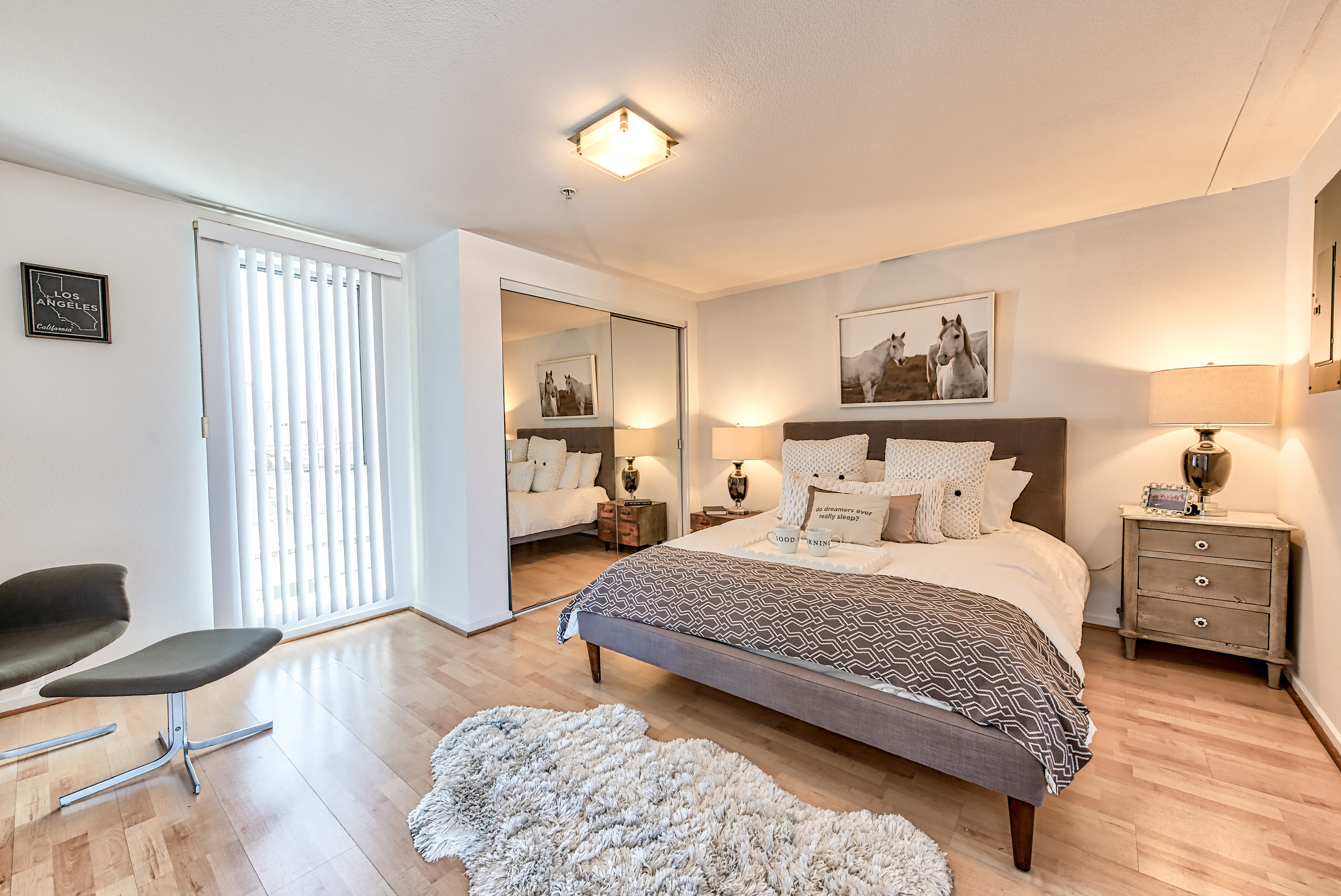 A bedroom with a bed, chair, and a rug.